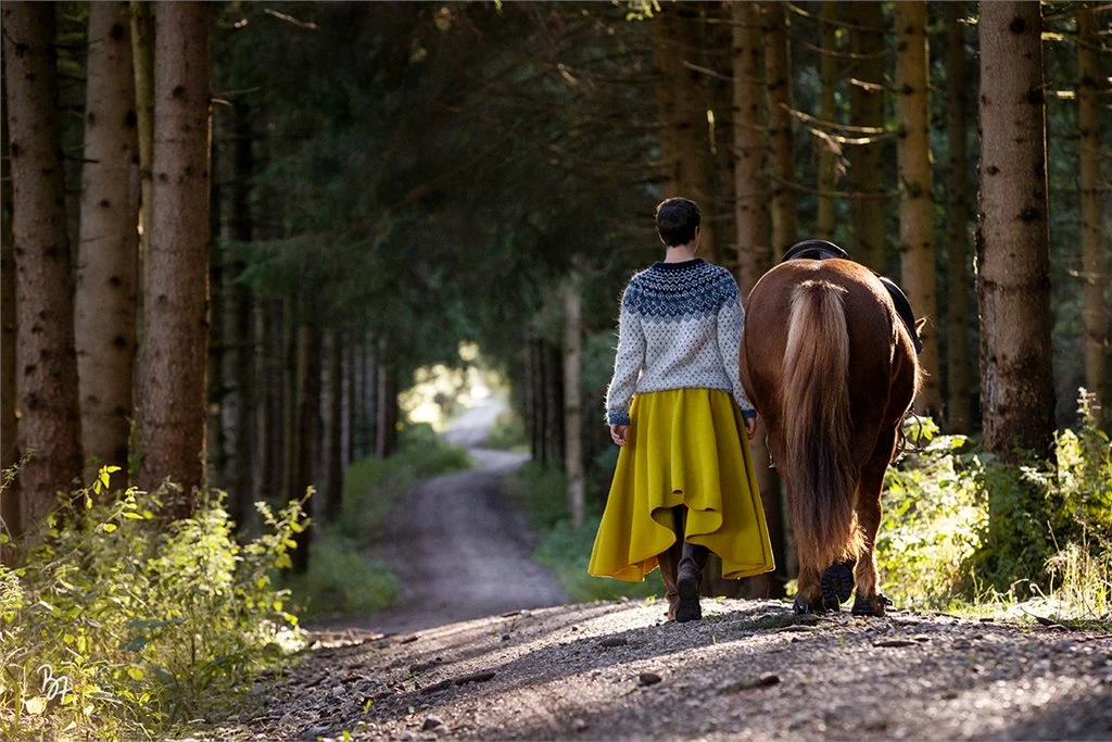 Kerstin Kubick führt ein Pferd auf einem Waldweg
